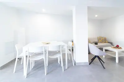 a white dining room with a white table and chairs at Global Vacacional, Deslumbrante casa en la playa de Sagunto in Sagunto