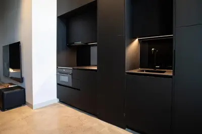 a kitchen with black cabinets and a sink at Crudo un Loft centrico de 50 m2 in Valencia