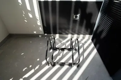 a metal chair sitting in the shadows of a building at Crudo un Loft centrico de 50 m2 in Valencia