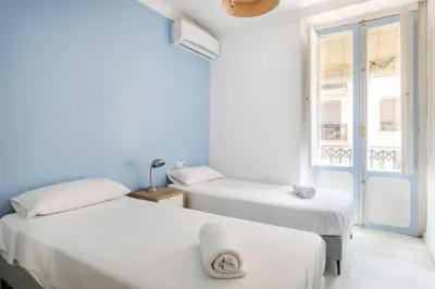 two beds in a white room with a window at Super Flat 3 rooms 1 toilet Center wifi AC in Valencia