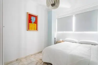 a bedroom with a white bed and a painting on the wall at Super Flat 3 rooms 1 toilet Center wifi AC in Valencia