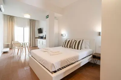 a white bedroom with a large bed with towels on it at VLC Host - Vicente Brull in Valencia