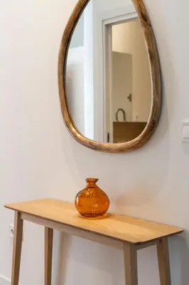 a wooden table with a mirror on a wall at VLC Host - Vicente Brull in Valencia