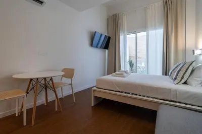 a bedroom with a bed and a table and a window at VLC Host - Vicente Brull in Valencia
