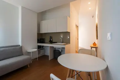 a small living room with a table and a kitchen at VLC Host - Vicente Brull in Valencia