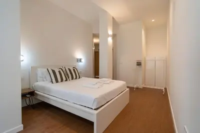 a bedroom with a white bed and a mirror at VLC Host - Vicente Brull in Valencia