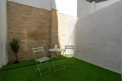 two chairs and a table in a room with grass at VLC Host - Vicente Brull in Valencia