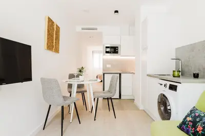 a living room with a table and chairs and a kitchen at Fantastico Apartamento en Valencia in Valencia