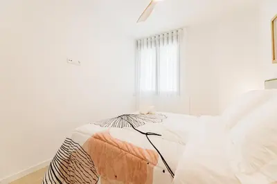 a white room with a bed with an umbrella on it at Fantastico Apartamento en Valencia in Valencia