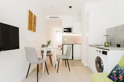 a living room with a table and chairs and a kitchen at Fantastico Apartamento en Valencia in Valencia