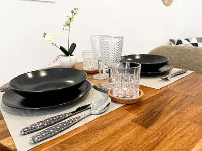 a wooden table with black plates and utensils on it at JB22 - Loft Valencia in Valencia