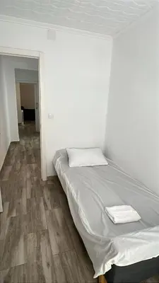 a white room with a bed with two towels on it at Apartamento acogedor playa Cullera in Cullera