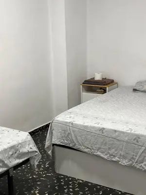 a bedroom with two beds and a side table at Aldair in Valencia