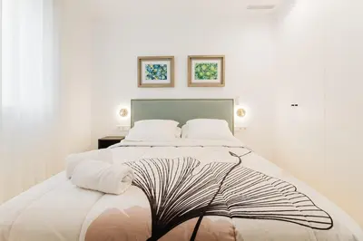 a white bedroom with a large bed with two pillows at Fantastico apartamento en Valencia in Valencia