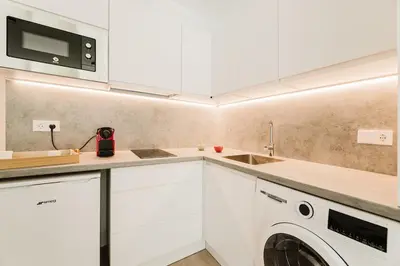 a kitchen with white cabinets and a washer and dryer at Fantastico apartamento en Valencia in Valencia