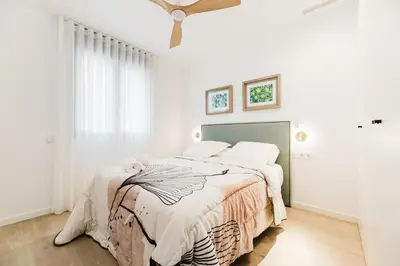 a white bedroom with a bed with a blanket at Fantastico apartamento en Valencia in Valencia