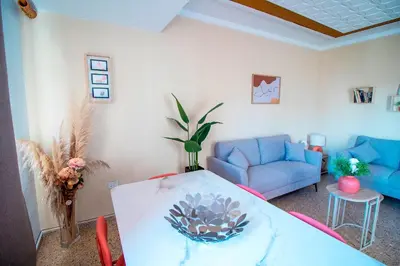 a living room with a table and a couch at Global Vacacional, Vivienda cozy en Puerto de Sagunto in Puerto de Sagunto