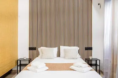 a bedroom with a bed with two side tables at Torrefiel Charm Apartment in Valencia