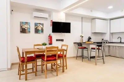 a kitchen and dining room with a table and chairs at Torrefiel Charm Apartment in Valencia
