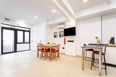 a kitchen and dining room with a table and chairs at Torrefiel Charm Apartment in Valencia