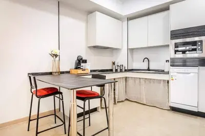 a kitchen with a table and two chairs and a sink at Torrefiel Charm Apartment in Valencia