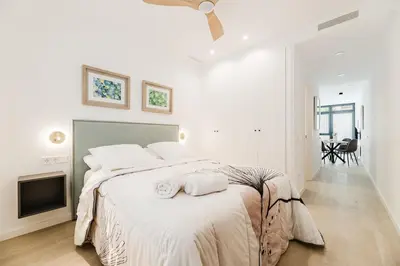 a white bedroom with a large bed with two towels on it at Apartamento en Valencia in Valencia