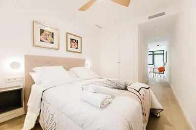 a white bedroom with a large bed with white sheets at Fantastico apartamento en Valencia in Valencia