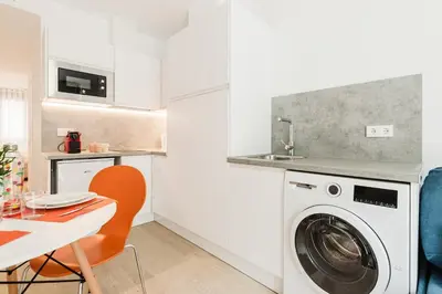 a kitchen with a washing machine and a table at Fantastico apartamento en Valencia in Valencia