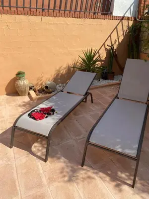 two chairs and a table with flowers on a patio at Las Salericas in Chella