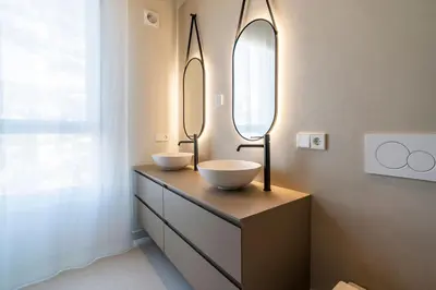 a bathroom with two sinks and two mirrors on a dresser at VLC Host - Martí Apartments in Valencia