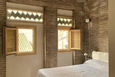 a bedroom with a bed and two windows at Casa Juana in Valencia
