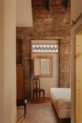 a bedroom with a bed and a chair and a window at Casa Juana in Valencia