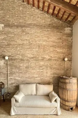 a living room with a couch and a brick wall at Casa Juana in Valencia
