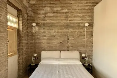 a bed in a room with a brick wall at Casa Juana in Valencia