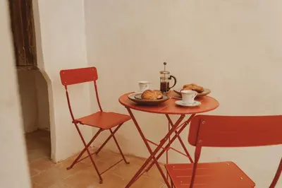 a small table with a plate of food and two chairs at Casa Rosalia in Valencia