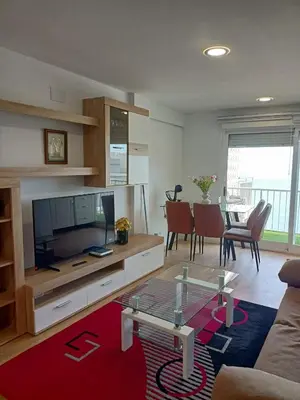 a living room with a couch and a tv and a table at APARTAMENTO Claudia FARO in Faro de Cullera