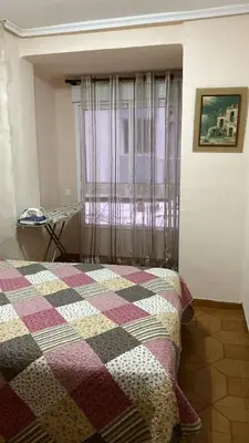 a bedroom with a bed with a checkered blanket at Apartamento en Cullera playa con amplio balcón in Cullera