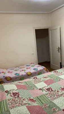 a bedroom with two beds with a quilt on it at Apartamento en Cullera playa con amplio balcón in Cullera