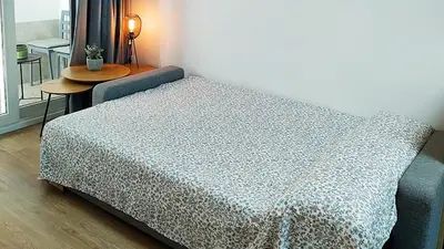 a bed sitting in a room with a table at LUXURY APARTMENT SCIENCES CITY Valencia B in Valencia