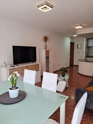 a living room with a table and white chairs at APARTAMENTO COMODO FERIA dE VALENCIA in Valencia