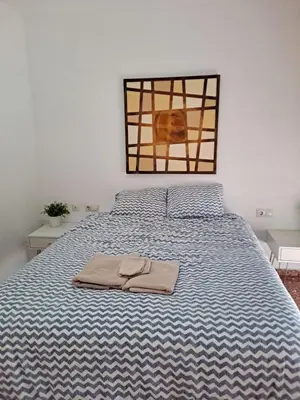 a bedroom with a bed with a blue and white blanket at APARTAMENTO COMODO FERIA dE VALENCIA in Valencia