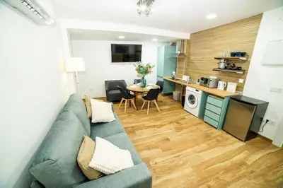 a living room with a blue couch and a kitchen at Playa Las Arenas 2 Apartamento in Valencia