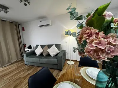 a living room with a couch and a table with flowers at Playa Las Arenas 2 Apartamento in Valencia