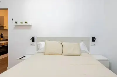 a white bed with two pillows on top of it at Nuevo acogedor cerca del Centro in Valencia