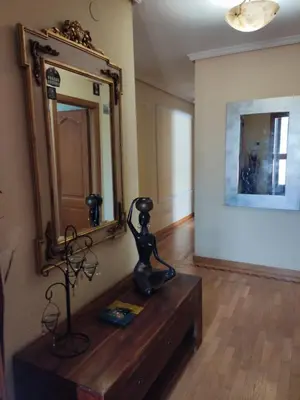 a room with a mirror and a table with a statue at fully-equipped luxury penthouse in Almácera