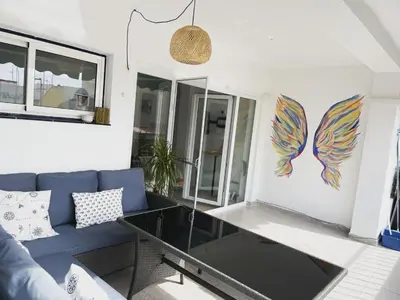a living room with a blue couch and a glass table at Seaview escape - spacious 3 bed beach apartment & terrace in Puerto de Sagunto