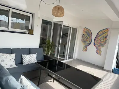 a living room with a blue couch and a glass table at Seaview escape - spacious 3 bed beach apartment & terrace in Puerto de Sagunto