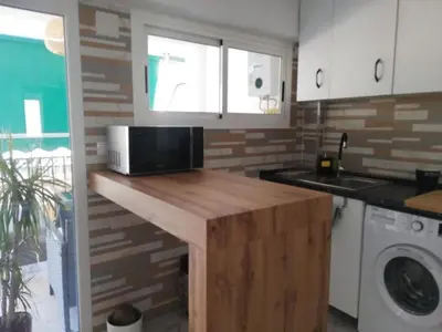 a kitchen with a microwave on a wooden counter at Seaview escape - spacious 3 bed beach apartment & terrace in Puerto de Sagunto
