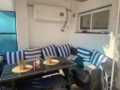 a living room with blue and white chairs and a table at Seaview escape - spacious 3 bed beach apartment & terrace in Puerto de Sagunto