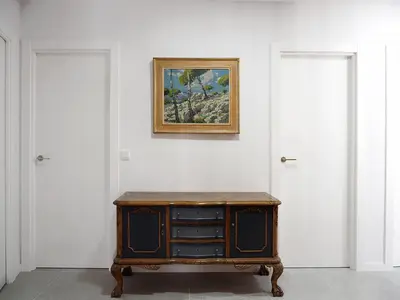 a dresser in a room with a painting on a wall at Apartamentos SAN JOSÉ in El Puig